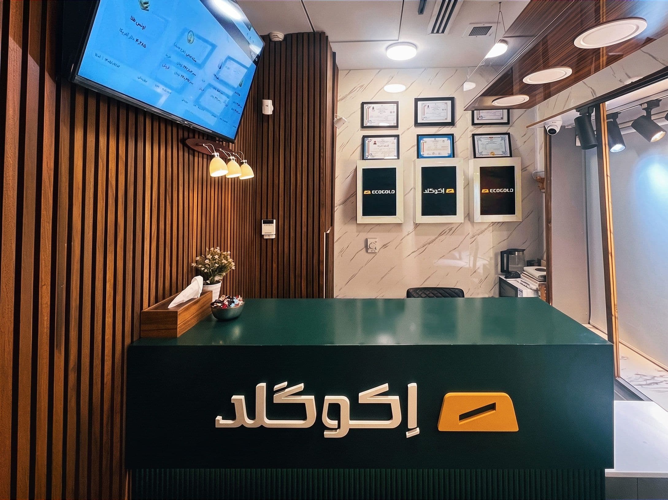 پیشخوان پذیرش شعبه با نمایشگر قیمت لحظه‌ای و مجوزهای نصب‌شده روی دیوار